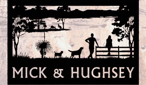 A metal cutout sign depicts a rural scene with trees, animals, and two people near a fence. One person stands with a dog while the other leans against the fence. The words "Mick & Hughsey" are displayed at the bottom