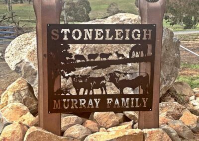 A picturesque view of Stoneleigh Murray Family Farm, showcasing lush fields and a charming farmhouse under a clear blue sky.