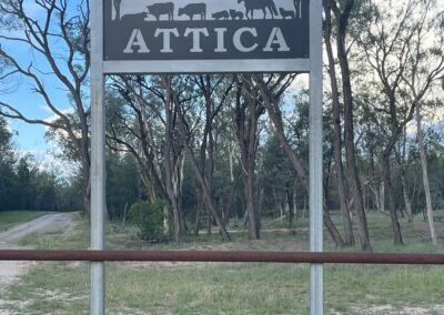 A sign reading "Attica" prominently displayed in the center of a vast, open field under a clear sky.