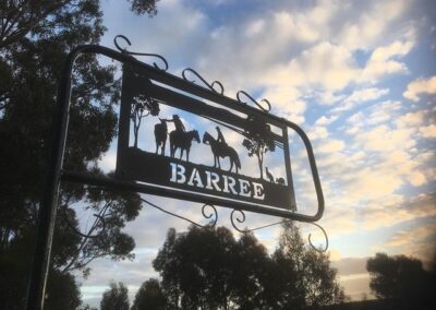 A sign reading "barree" positioned in front of a backdrop of trees.