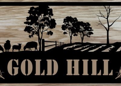 A rustic sign displaying "Gold Hill Farm," set against a picturesque rural backdrop.