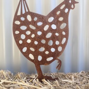 Rusted metal hen silhouette with cut-out patterns, standing on a straw surface against a striped background.