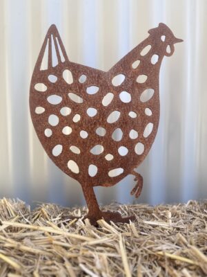 Rusted metal hen silhouette with cut-out patterns, standing on a straw surface against a striped background.