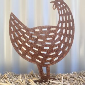 Rustic metal chicken silhouette on straw with a corrugated iron background.