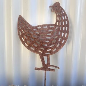 Rusty metal chicken silhouette against a corrugated background, standing on straw.