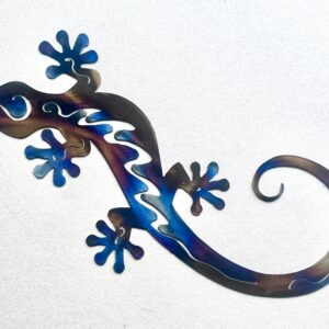 Metallic gecko sculpture with blue and purple hues on a white background.