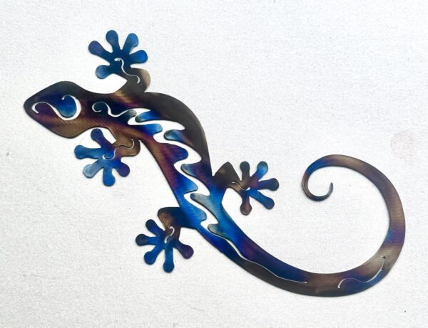 Metallic gecko sculpture with blue and purple hues on a white background.