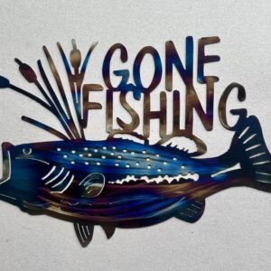 Colorful metal fish-shaped sign with "GONE FISHING" text on a textured background.