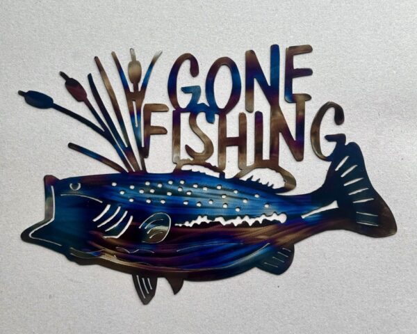 Colorful metal fish-shaped sign with "GONE FISHING" text on a textured background.