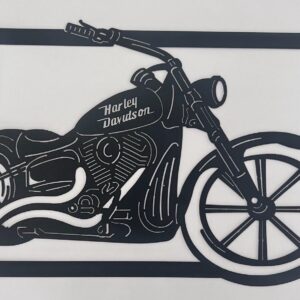 Black silhouette cut-out of a Harley Davidson motorcycle against a white background.