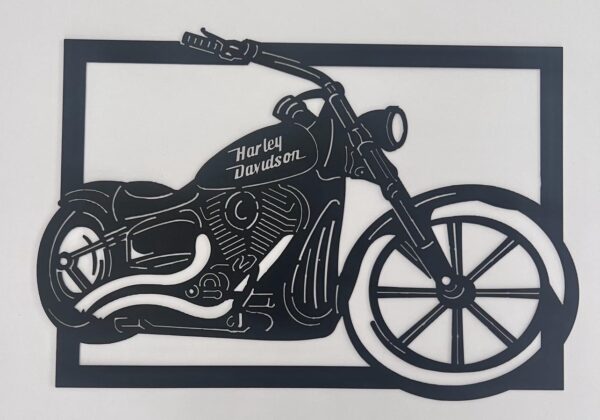 Black silhouette cut-out of a Harley Davidson motorcycle against a white background.