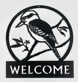 Circular black metal "Welcome" sign with a silhouette of a woodpecker on a branch.