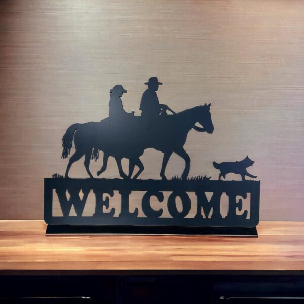 Silhouette of a cowboy, dog, and horse with "WELCOME" text on a wooden shelf.