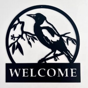 Circular black silhouette of a bird on branches with a "WELCOME" sign below.