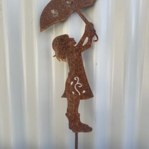 Rusted metal silhouette of a girl holding an umbrella against a corrugated backdrop.