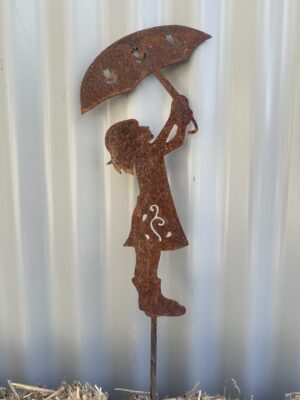 Rusted metal silhouette of a girl holding an umbrella against a corrugated backdrop.