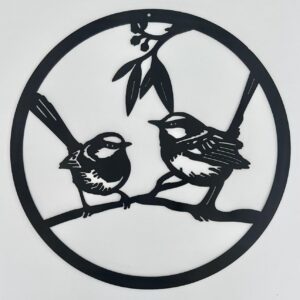 Black metal wall art of two birds perched on a branch within a circular frame.