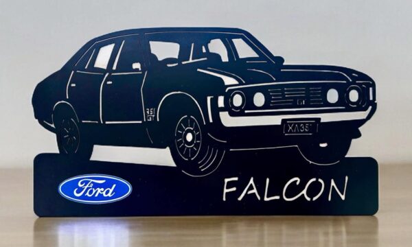 Silhouette of a Ford Falcon car with logo and model name on display stand.