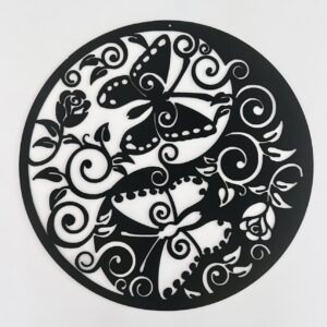 Circular black and white art piece with floral and butterfly designs in silhouette.