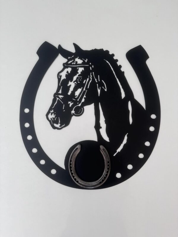 Black silhouette of a horse's head within a horseshoe on a white background.