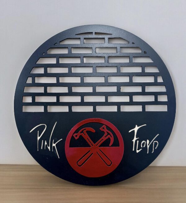 Round metal Pink Floyd decor featuring band's name and crossed hammer logo.