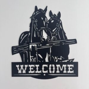 Black metal wall art featuring two horses' heads above a "WELCOME" sign.