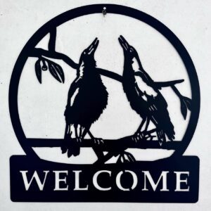 Silhouetted raven "Welcome" sign against a white wall.