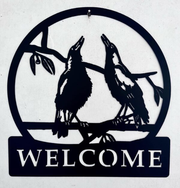 Silhouetted raven "Welcome" sign against a white wall.