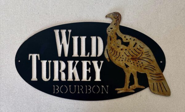 Oval-shaped sign with "Wild Turkey Bourbon" text and turkey graphic on black background.